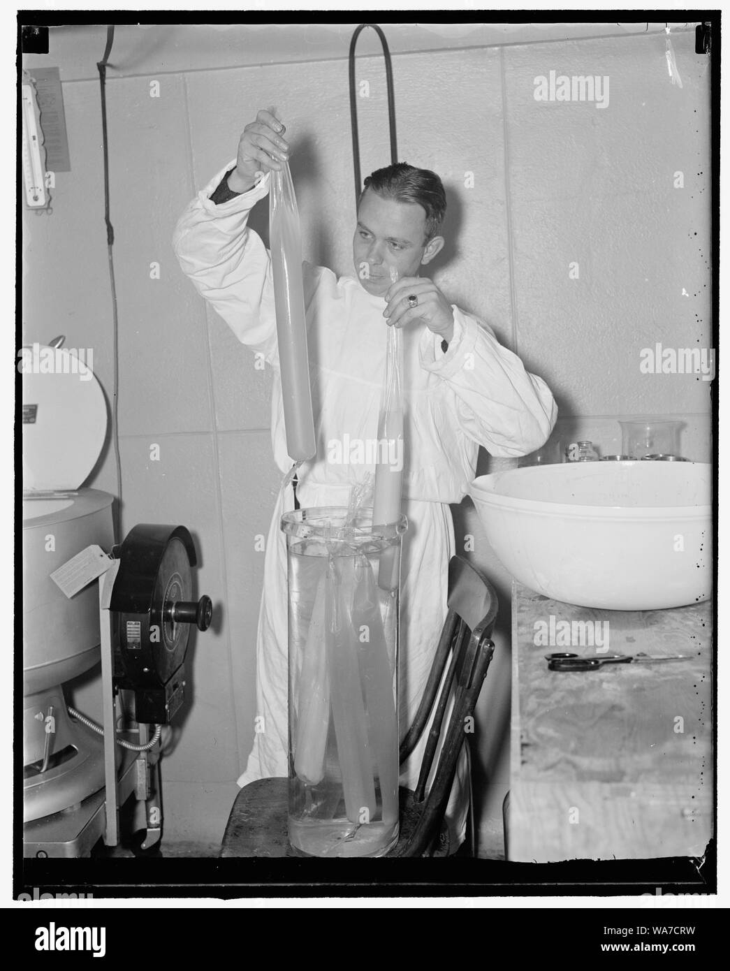 Esercito dichiara guerra alla polmonite. Washington D.C., Sett. 1. La Army Medical Center è la preparazione di un vaccino contro la polmonite per la prima scala di massa inoculazione mai tentato nella battaglia contro la malattia. I volontari della CCC saranno l'umano cavie in esperimento. Questo vaccino, che è dieci volte più costoso come oro, è effettuata per distribuzione di questo autunno a tutti i CCC enrollees che desiderano che le vaccinazioni. Gli ufficiali si aspettano di avere abbastanza vaccino per la salvaguardia di 300.000 individui. Il capitano John R. legno, è mostrato con il parzialmente purificato prodotto quando esso dializzato in cellofan sa Foto Stock