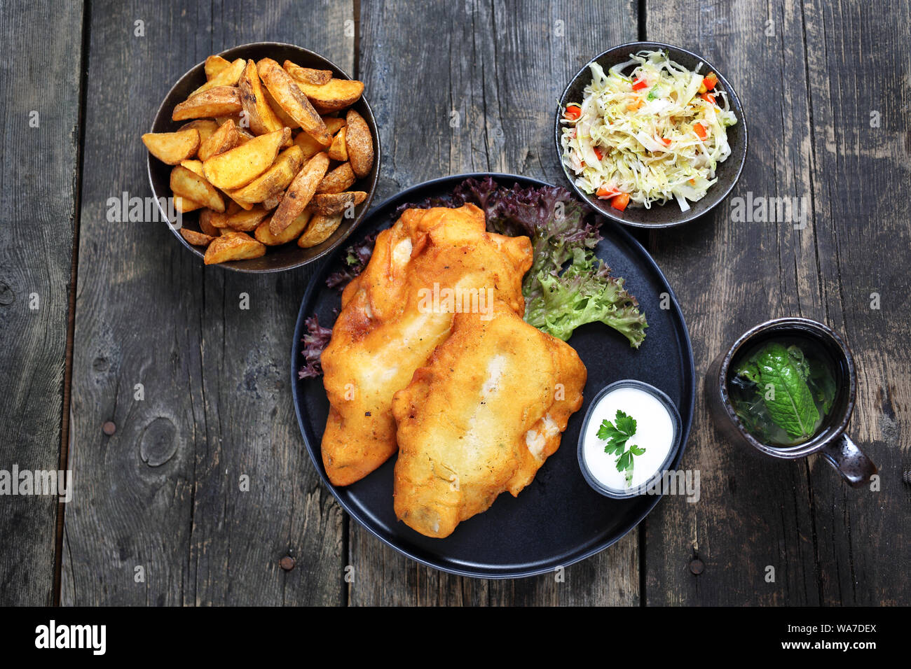 Pesce fritto in pastella con patatine e insalata. Foto Stock