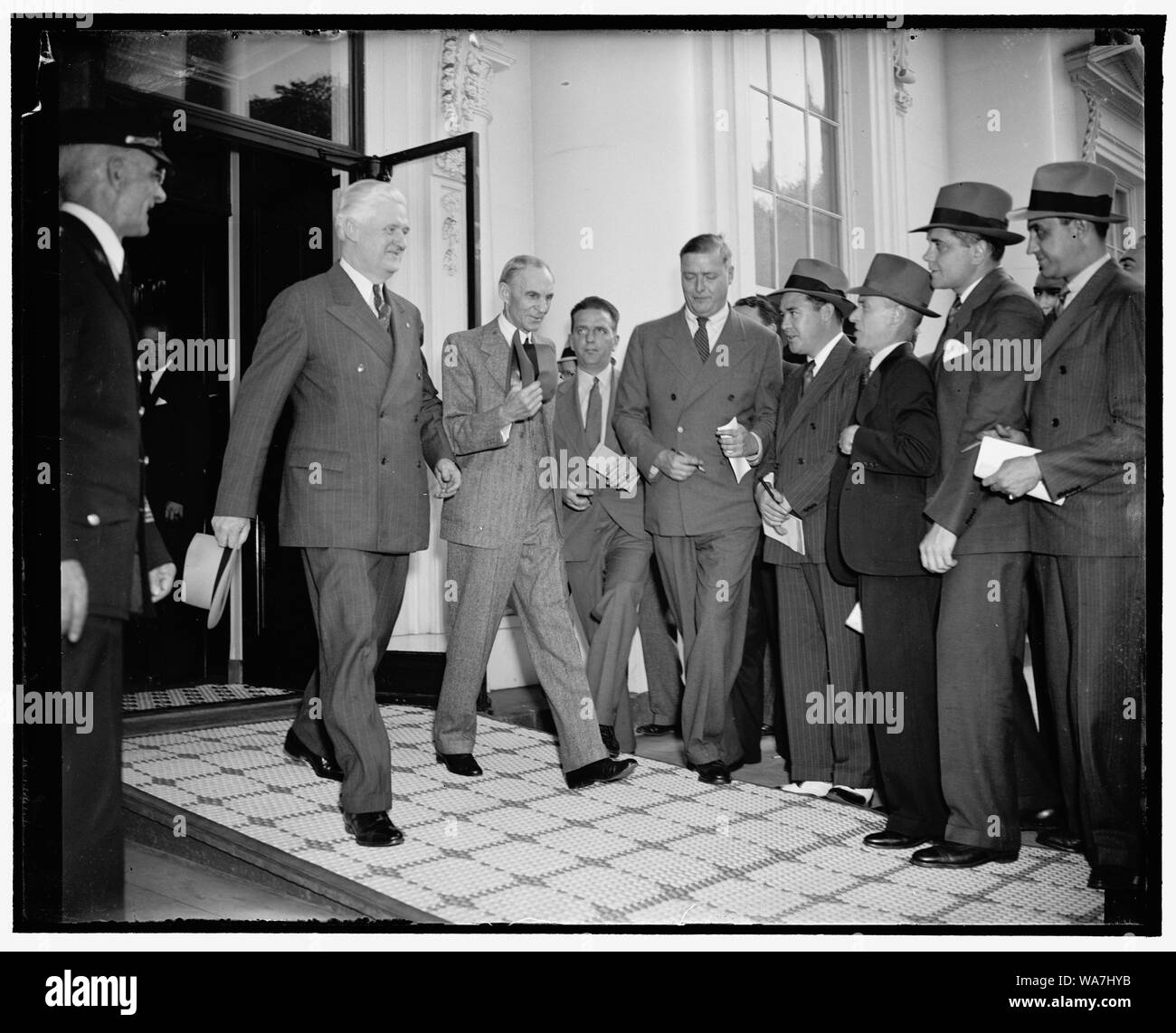 Magnate Auto lascia la Casa Bianca dopo la conferenza con il presidente Roosevelt. Washington, 27 aprile. Costretto a eseguire un gantlet di giornalisti, Henry Ford è raffigurato di lasciare la Casa Bianca oggi con il Mag. Henry M. Cunningham, Manager di Alexandria, VA.O ramo della Ford Motor Co., dopo un pranzo e conferenza con Presdient Roosevelt. Sia la Casa Bianca e la Ford ha rifiutato di fare una dichiarazione a seguito della discussione che è durato un paio di ore, 4/27/38 Foto Stock