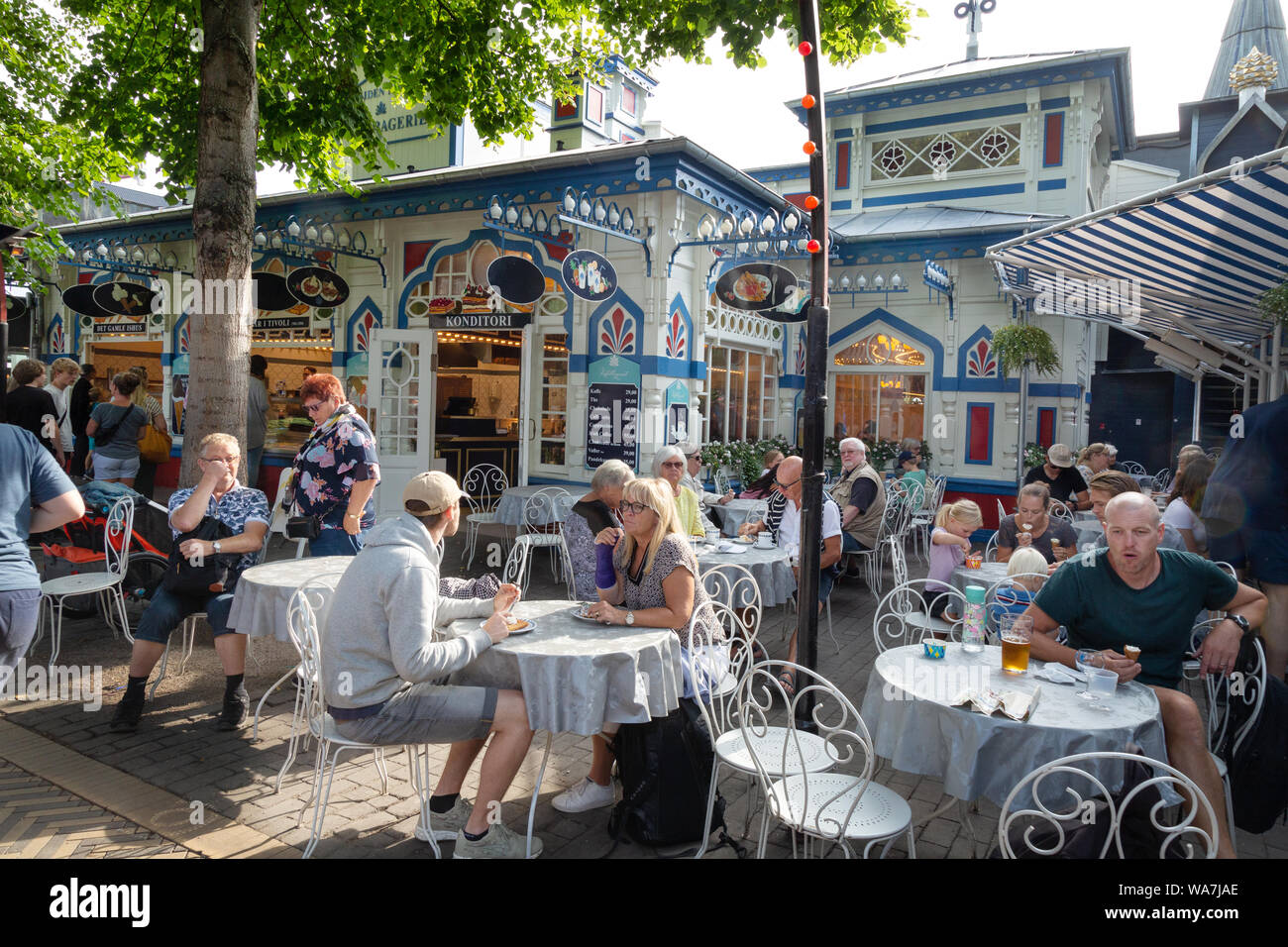 La gente seduta a un parco divertimenti Giardini di Tivoli cafe, Copenhagen DANIMARCA Scandinavia Europa Foto Stock