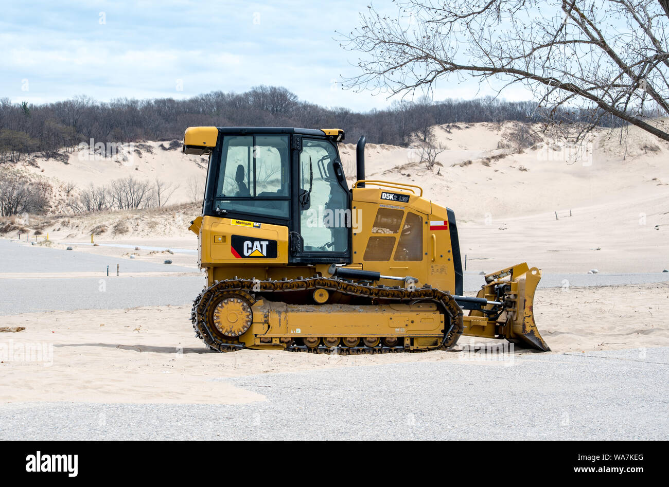 1 maggio 2018 Bridgman MI USA un bulldozer l si sposta di sabbia a Warren Dunes State Park, a pulire soffiando sabbia dal parcheggio dopo un lungo inverno Foto Stock