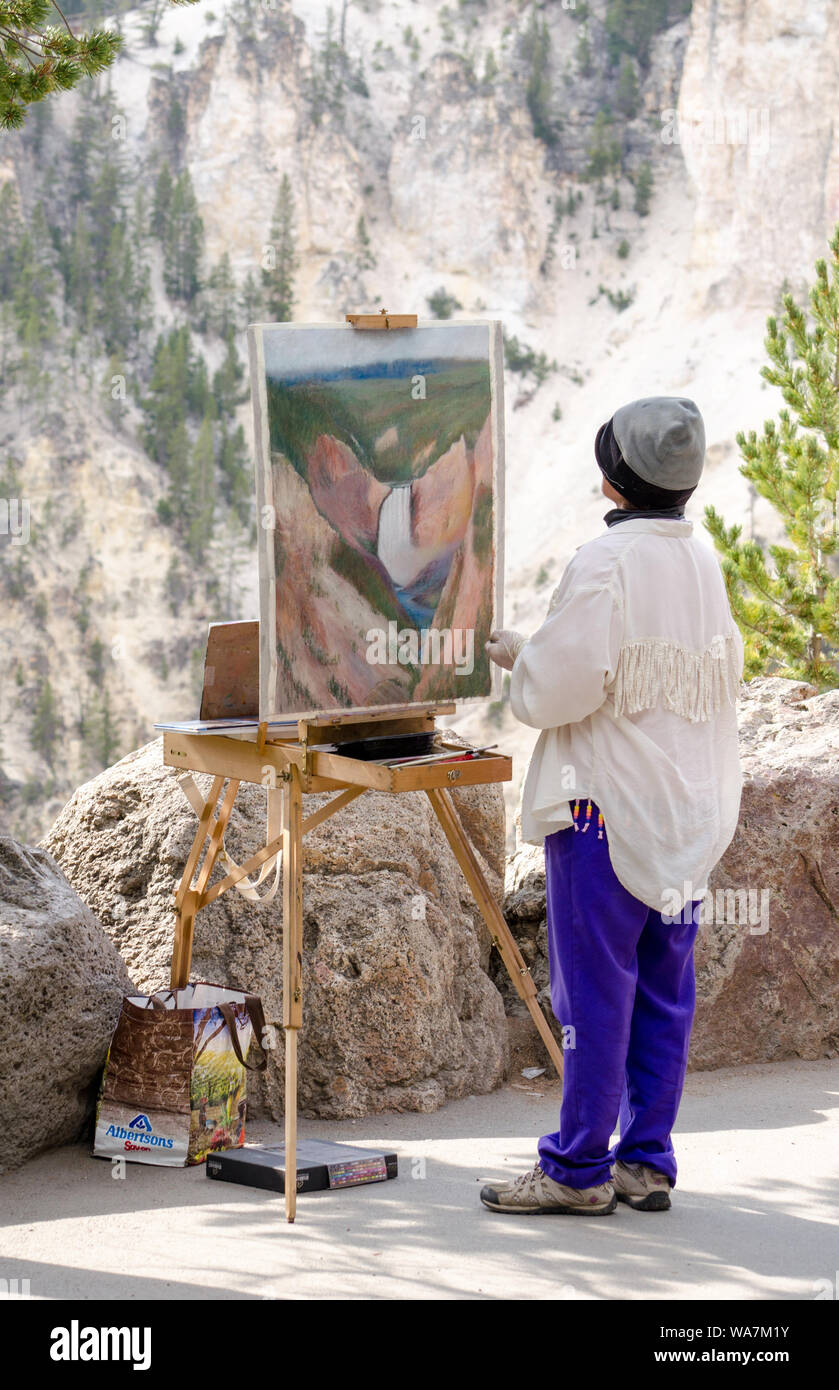 Un pittore lavora su una bella opera d'arte mentre a Yellowstone National Park storici pittori punto cascata Foto Stock