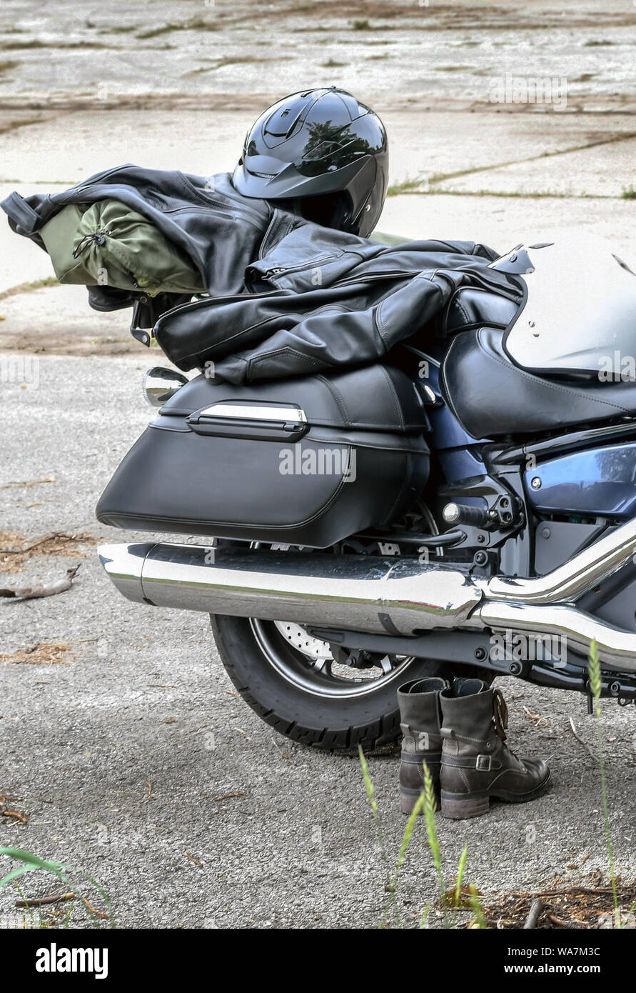 Una coppia di uomini stivali del resto lungo il lato di una motocicletta, tutti pronti per un viaggio su strada Foto Stock