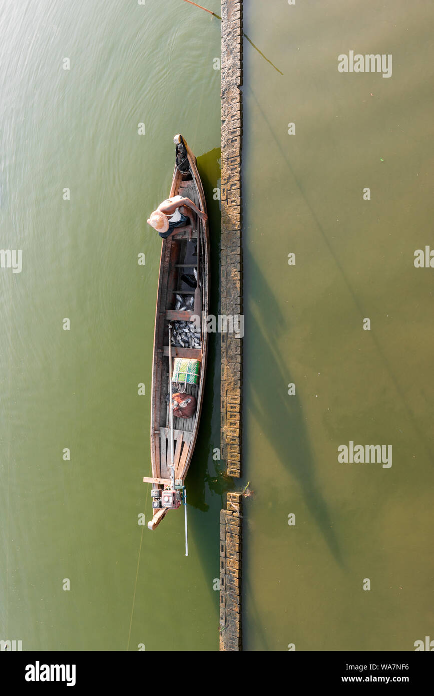 Da cima a fondo foto del locale di pescatori birmani all'interno di una barca di legno sotto la U Bein Bridge si trova a Mandalay, Myanmar Foto Stock