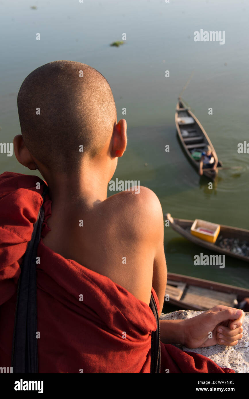 Immagine del giovane monaco buddista cercando barche da U Bein Bridge si trova a Mandalay, Myanmar Foto Stock