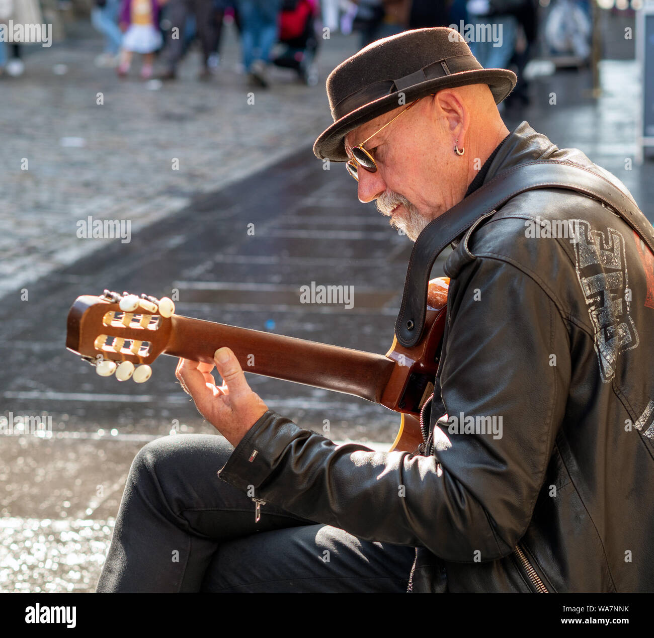Un chitarrista intrattiene i passanti nelle vicinanze del Castello di Edinburgo sul Royal Mile di Edimburgo, Scozia, Regno Unito. Foto Stock