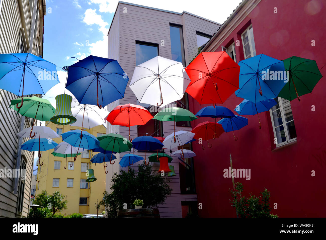 Ombrelloni colorati e lanterne sospese tra due edifici di Bergen, Norvegia. Foto Stock