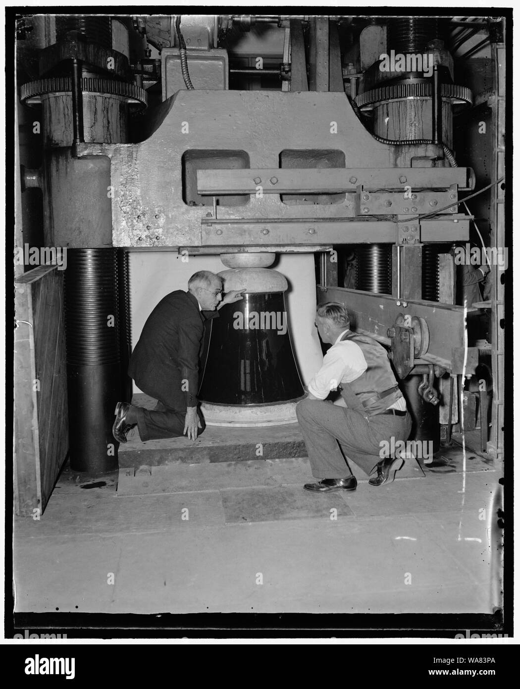 Bureau of Standards mette ruge isolante attraverso prove di pressione. Washington D.C., nov. 30. H.L. Whitemore, (sinistra), direttore di ingegneria meccanica sezione, National Bureau of Standards e il dottor A.H. Stand, effettuare un controllo finale degli enormi 1600[] pound isolatore di porcellana prima di sottoporlo a 2,180,000 libbre pressione nell'Ufficio di presidenza del martinetto idraulico. L'isolatore, una delle poche delle sue dimensioni in esistenza, servirà come base per un 640 piedi il montante alla stazione radio WGY, Schenectady, New York. Uno degli isolatori sorgeva con successo la pressione di 800.000 libbre mentre il secondo si è rotto quando il Foto Stock