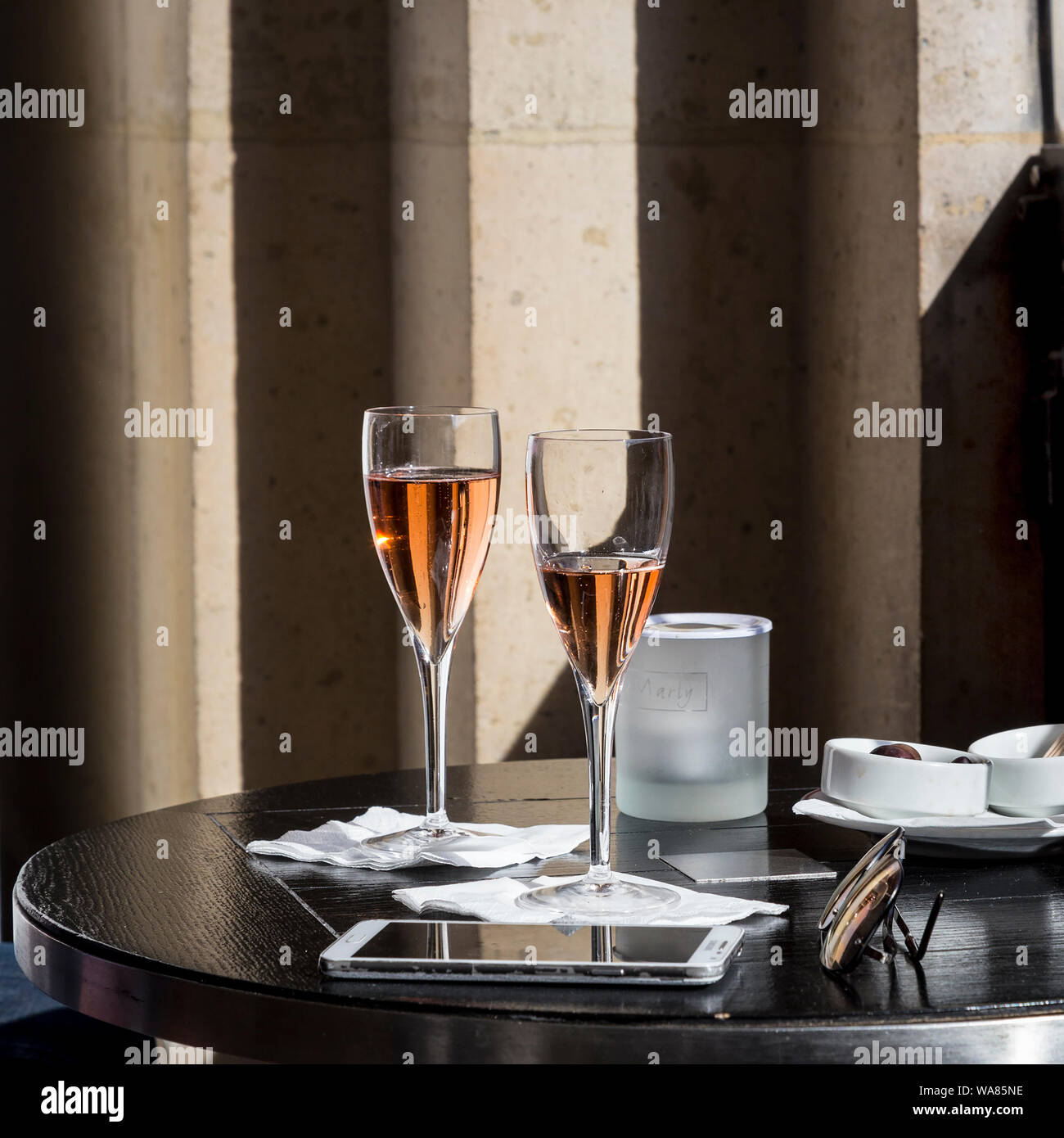 Cafe Marly No5 è stata presa al Cafe Marly, Parigi, Francia. Esso raffigura un elegante e romantico con due bicchieri di vino rosato su un nero tavola rotonda. Foto Stock