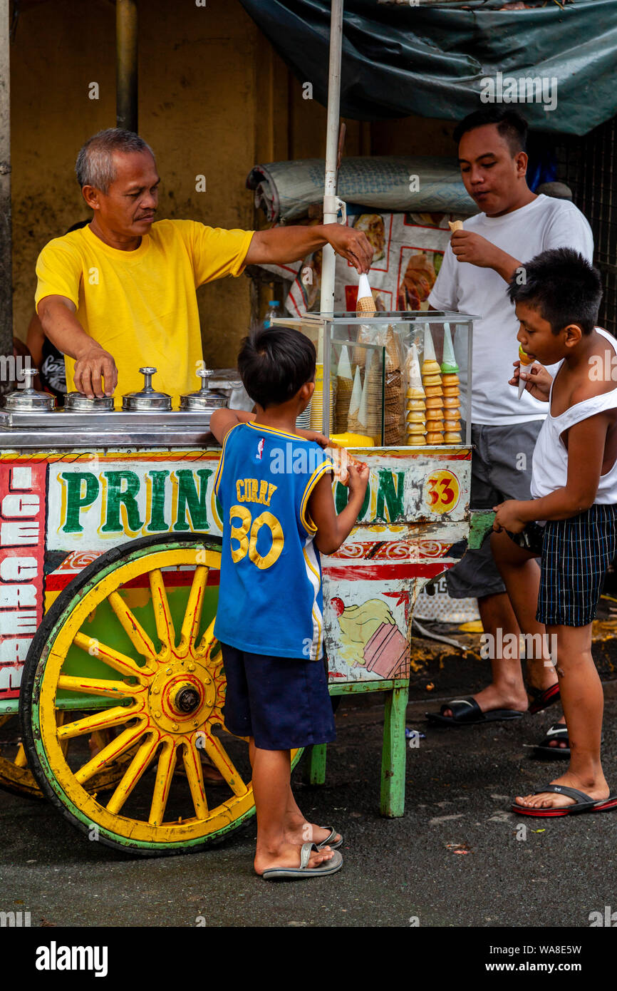 La popolazione locale Acquisto di gelati da un Mobile Carrettino In Intramuros, Manila, Filippine Foto Stock