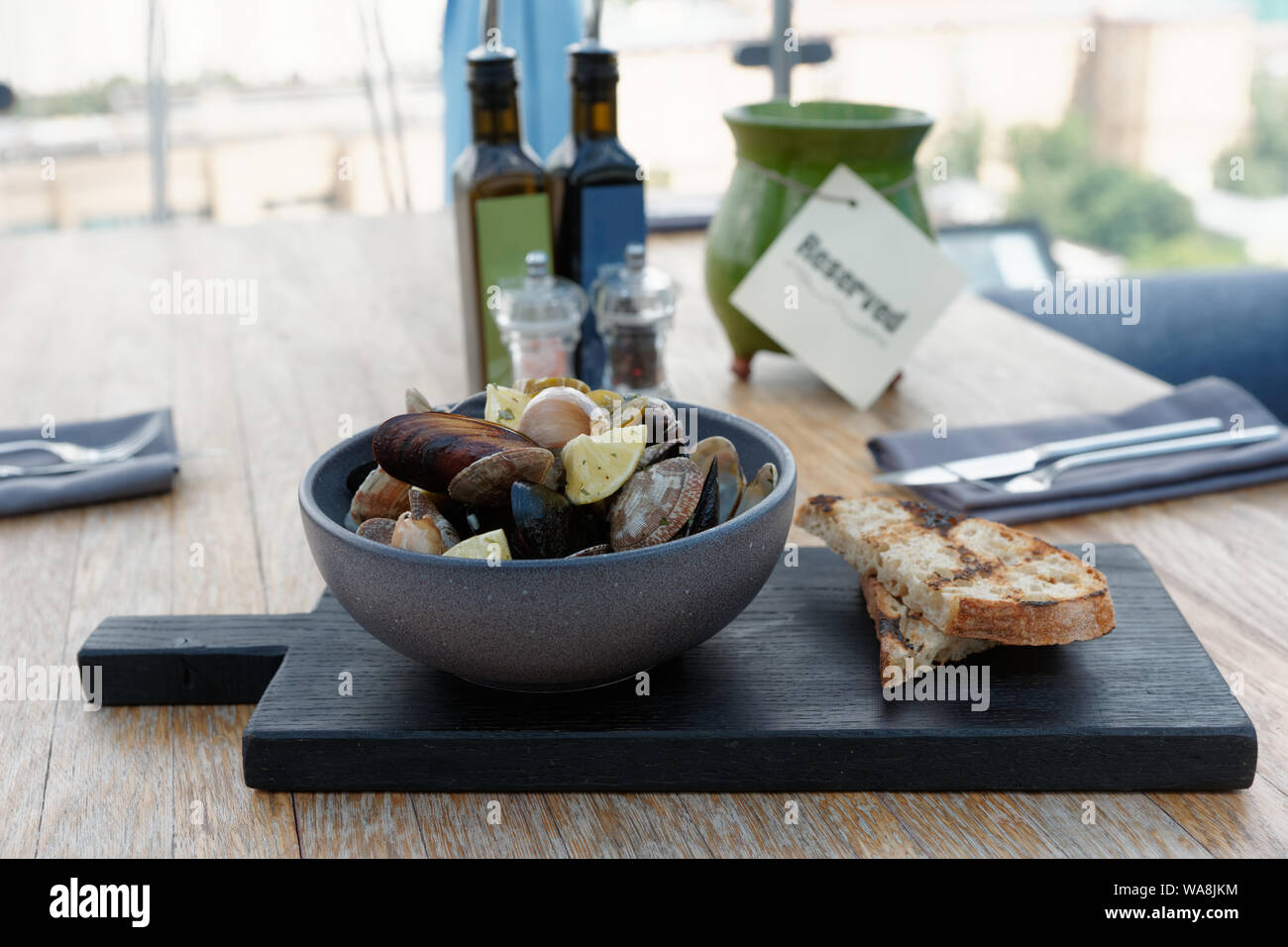 Shelfish rosolarli on dark tagliere su riservati ristorante tabella Foto Stock