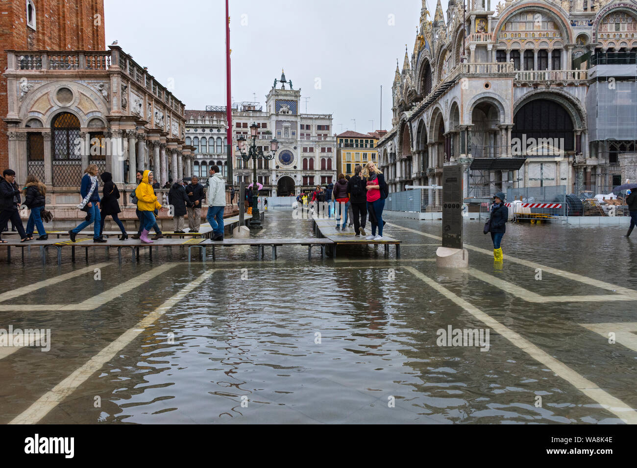La gente camminare su piattaforme elevate durante un'acqua alta (l'acqua alta) evento, la Piazzetta di San Marco, Venezia, Italia Foto Stock