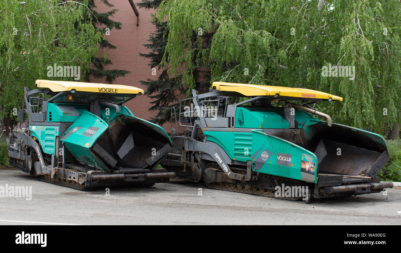 Il Kazakistan, Ust-Kamenogorsk - 22 Maggio, 2019. Attrezzature speciali per la costruzione di strade. Asfaltatrici su parcheggio. Asfalto lastricatore macchina Vogele. Foto Stock