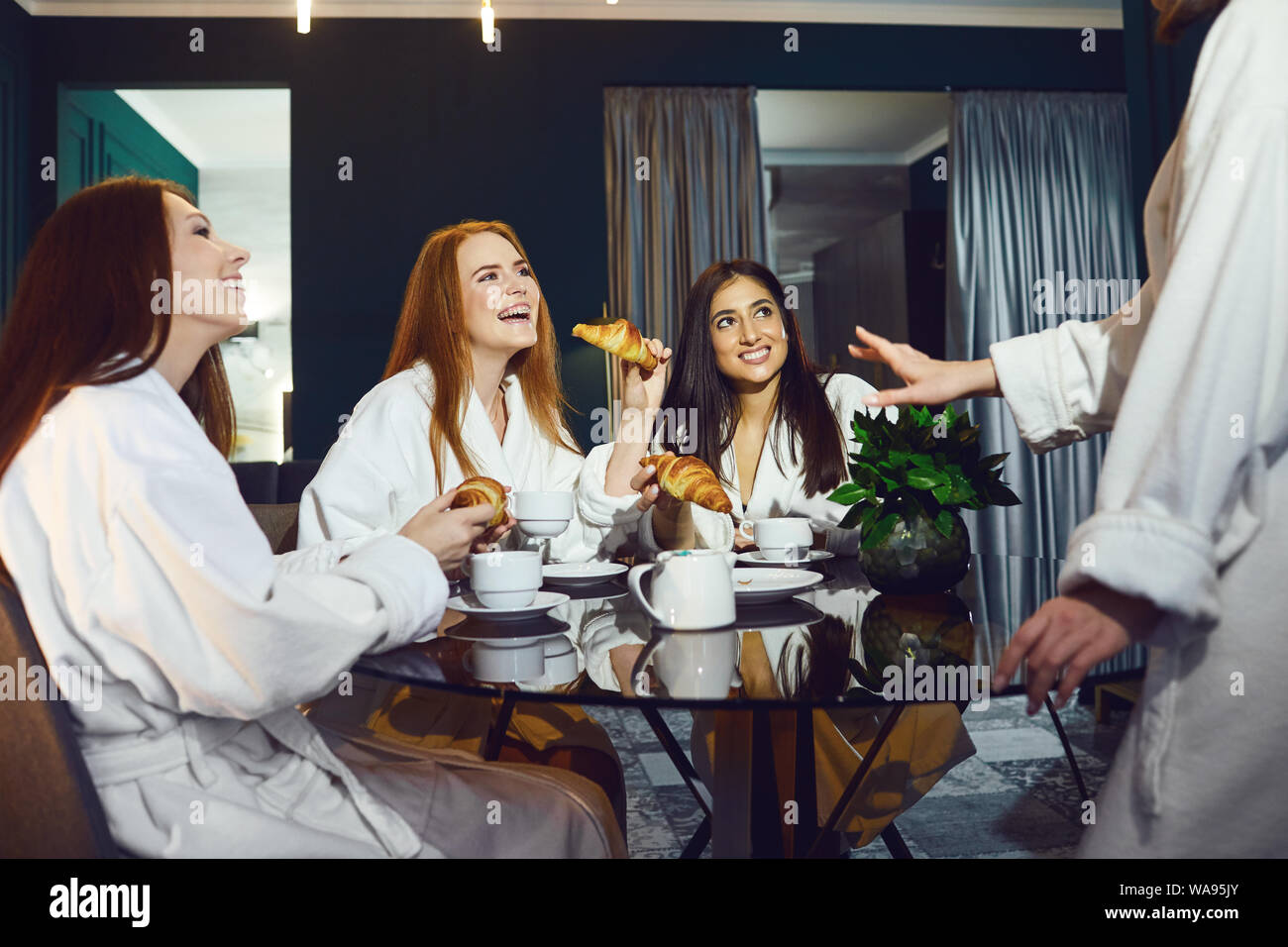 Giovani donne in accappatoio bianco con bicchieri di champagne in una spa party Foto Stock