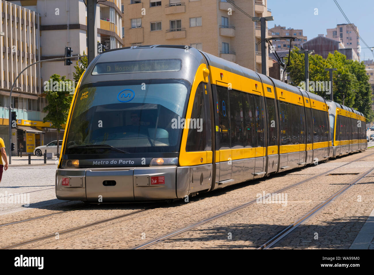 Il Portogallo Vila Nova de Gaia la metropolitana metropolitana Streamline Moderne al di sopra del suolo sezione street scene rotaie del tram ciottoli edifici alberi Foto Stock