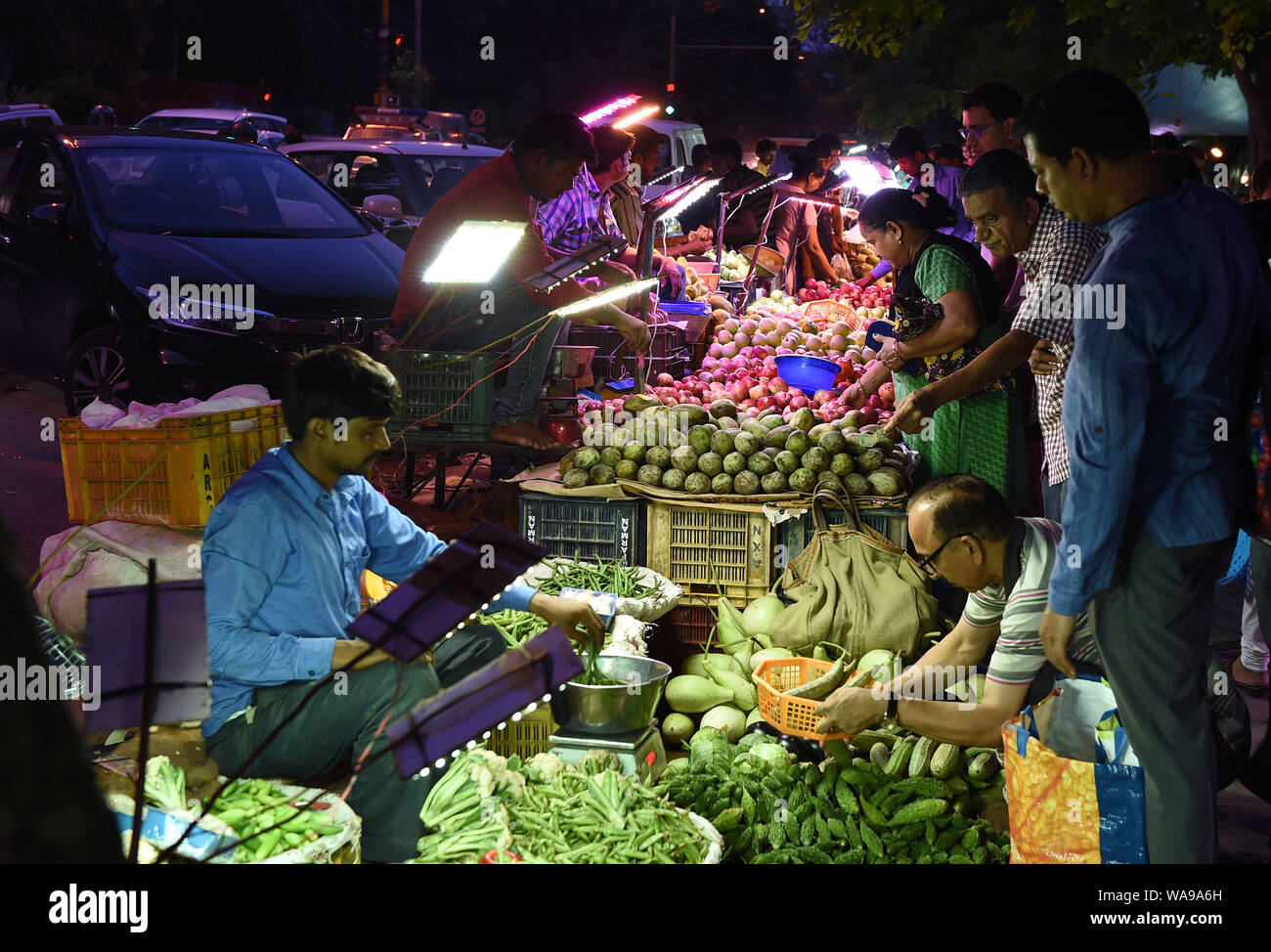 (190819) -- NEW DELHI, 19 Agosto, 2019 (Xinhua) -- persone selezionare le verdure sul mercato di domenica a Nuova Delhi, in India, e il agosto 18, 2019. Molti mercati di notte aperta nei fine settimana di New Delhi, attirando un numero di clienti per i prodotti freschi un prezzo inferiore. (Xinhua/Zhang Naijie) Foto Stock