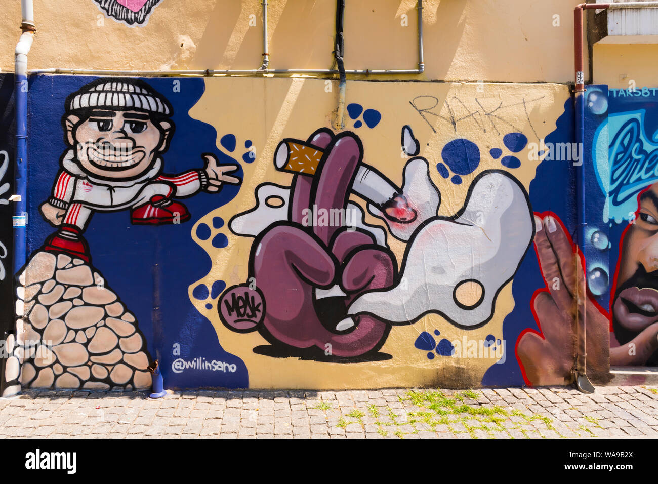 Portogallo Porto Porto graffiti carta murale foto street art Rua Sa Noronha @willinsano mesk comic figura pila di rocce mano Sigaretta fumare drainpipe Foto Stock