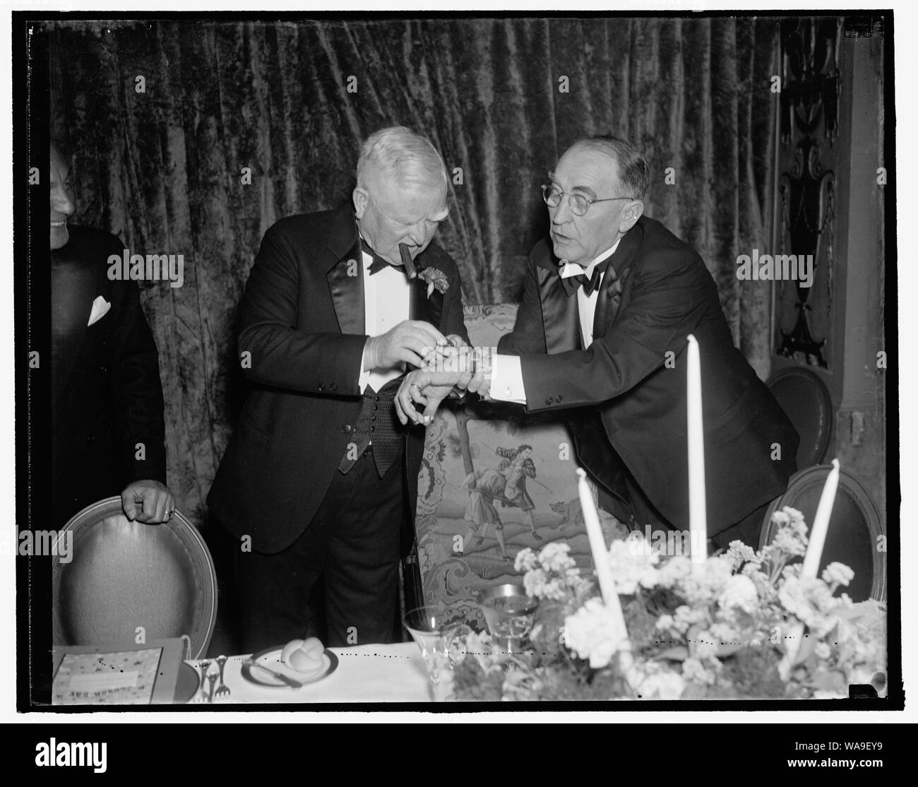 Controllare il Big Boss. Washington, 8 gennaio. Vice Presidente Garner e altoparlante Bankhead controllare i loro orologi come essi attendono l'arrivo del Presidente Roosevelt per la Jackson giorno cena stasera al Mayflower. Il presidente del tardo arrivo mantenuta la fame diners in attesa, 1/8/38 Foto Stock