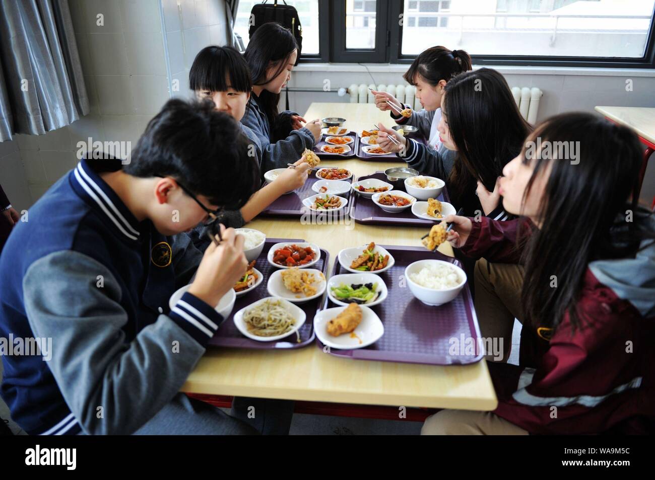 Studenti Cinesi mangiare il pranzo in mensa in una scuola nella città di Qingdao, Cina orientale della provincia di Shandong, 20 aprile 2017. Foto Stock