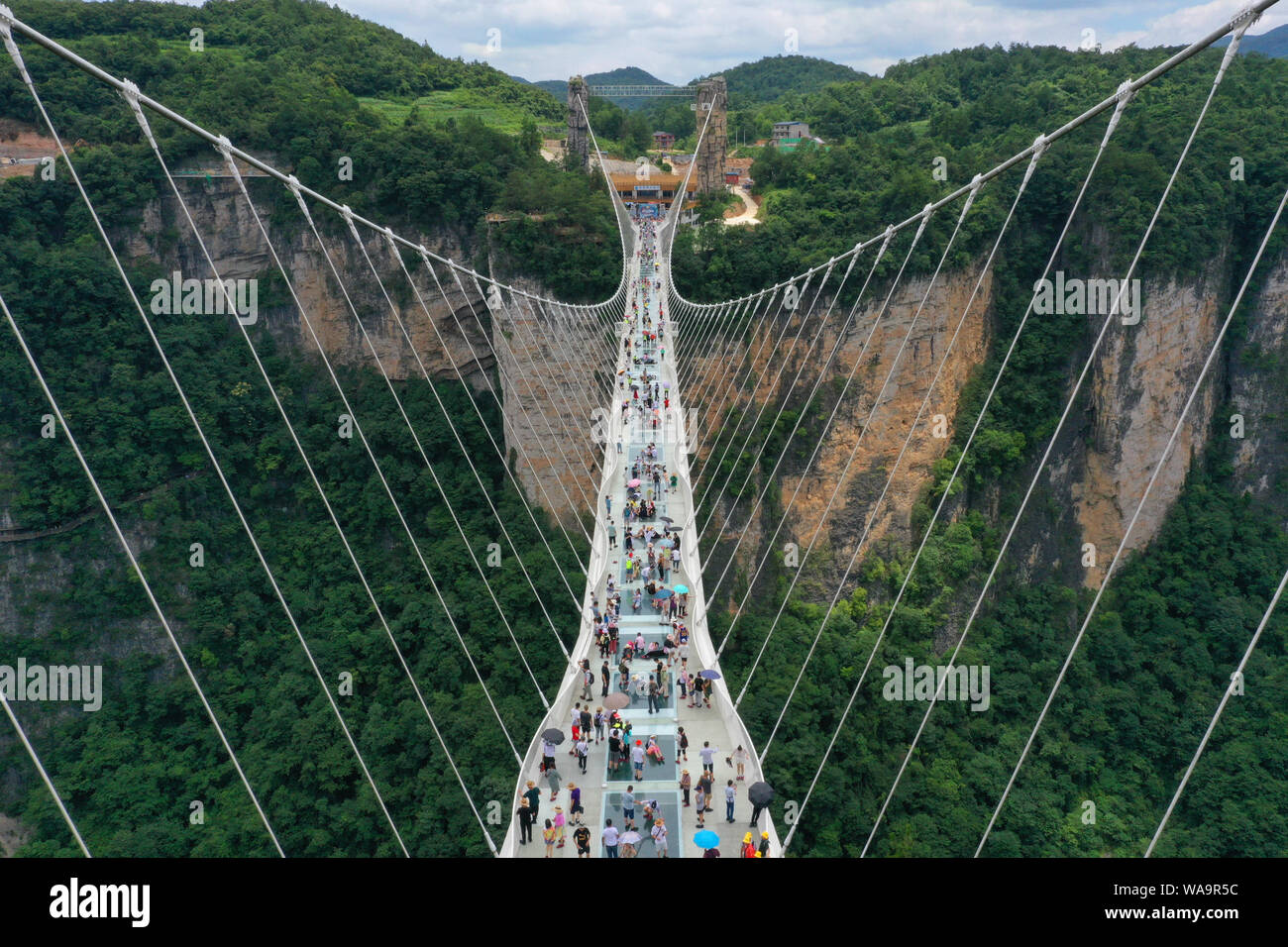 I turisti a piedi sulla più lunga del mondo e il più alto dal fondo di vetro ponte sopra il Zhangjiajie Grand Canyon a Wulingyuan Scenic e interesse storico Ar Foto Stock