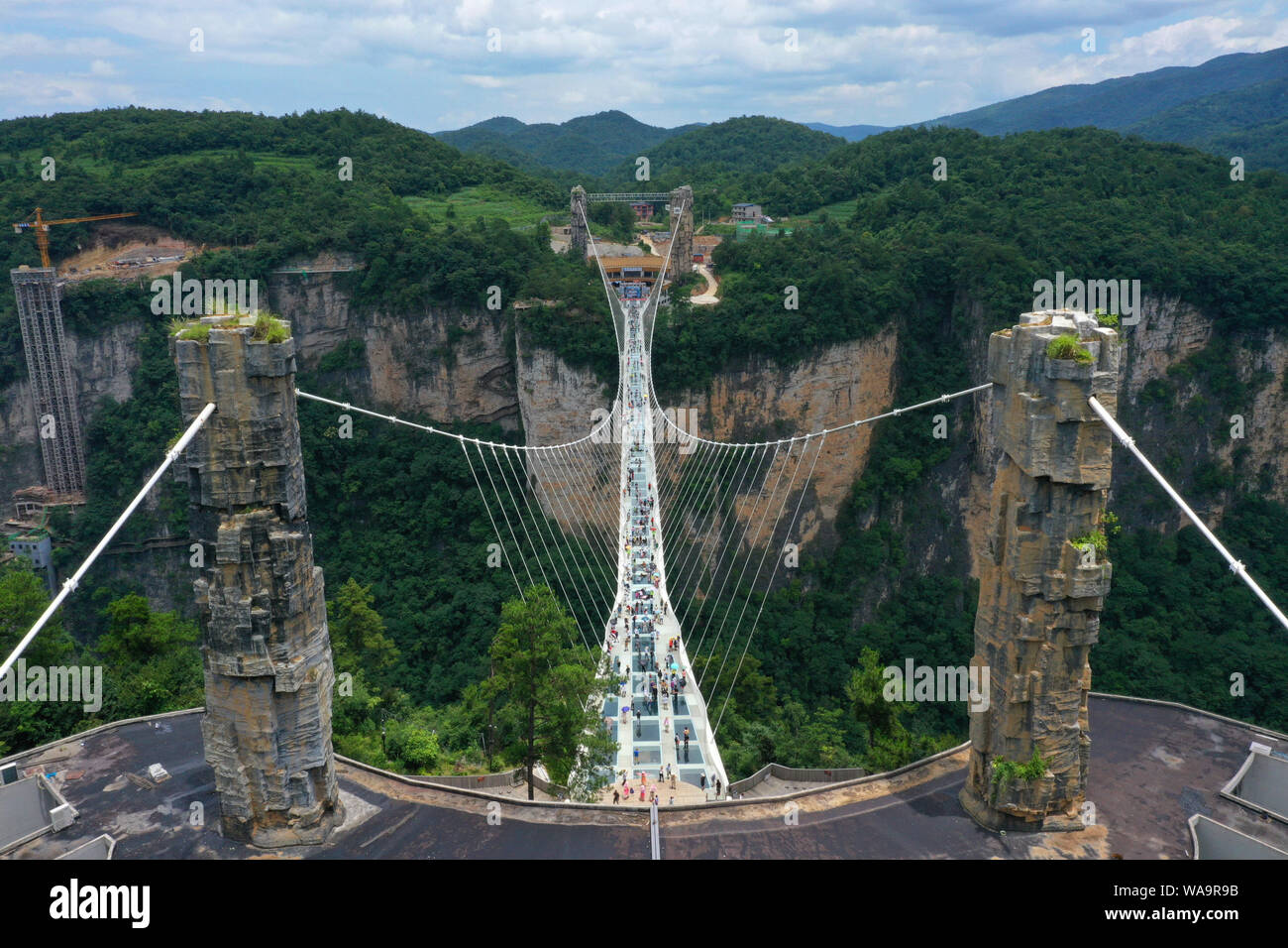 I turisti a piedi sulla più lunga del mondo e il più alto dal fondo di vetro ponte sopra il Zhangjiajie Grand Canyon a Wulingyuan Scenic e interesse storico Ar Foto Stock