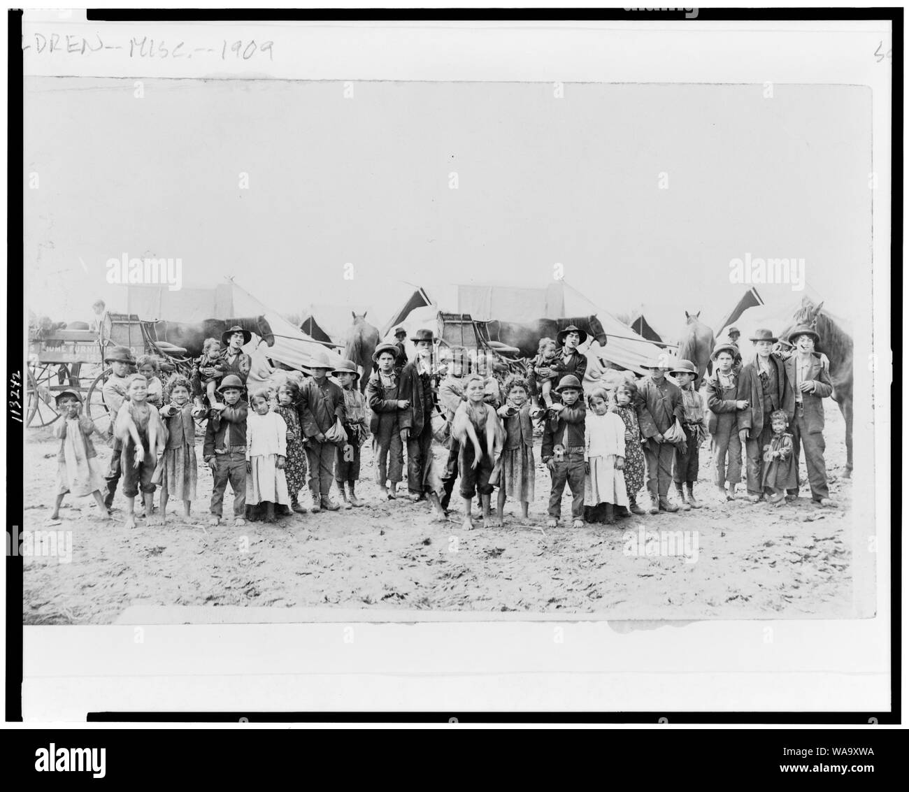 Bambini poste nella parte anteriore di carri trainati da cavalli e tende Foto Stock