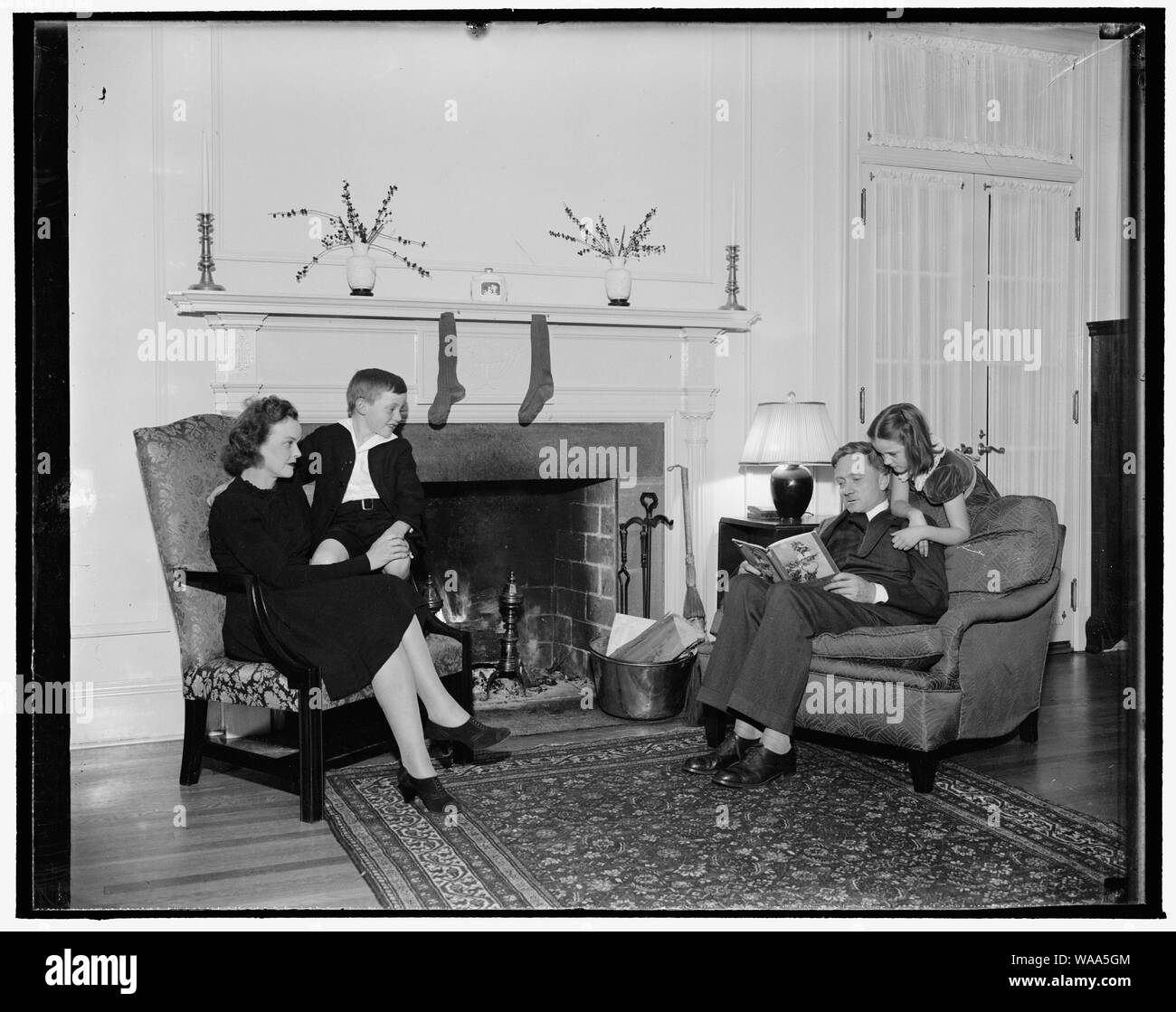 Vigilia di Natale a casa del giovane Suprema Corte di giustizia. Washington D.C., dic. 18. Associare la giustizia della corte suprema e la Sig.ra William O. Douglas con i loro figli, Mildred Riddle, e William O., Jr., reinterpreta questa scena presso la loro casa alla vigilia di Natale Foto Stock