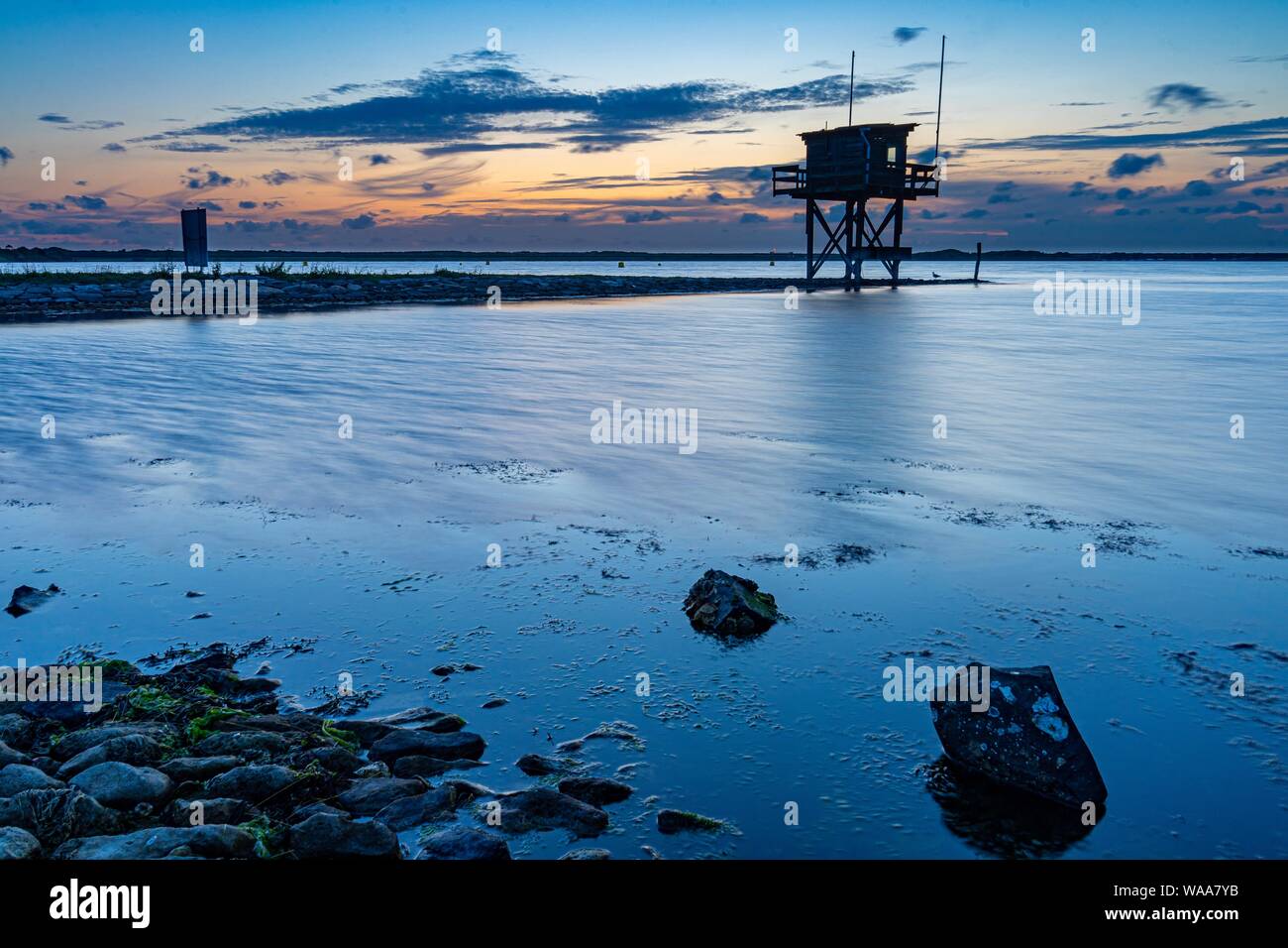 Tramonto al bellissimo lago a Scharendijke in Zeeland nei Paesi Bassi, la torre di avvistamento del divecenter in background. Foto Stock