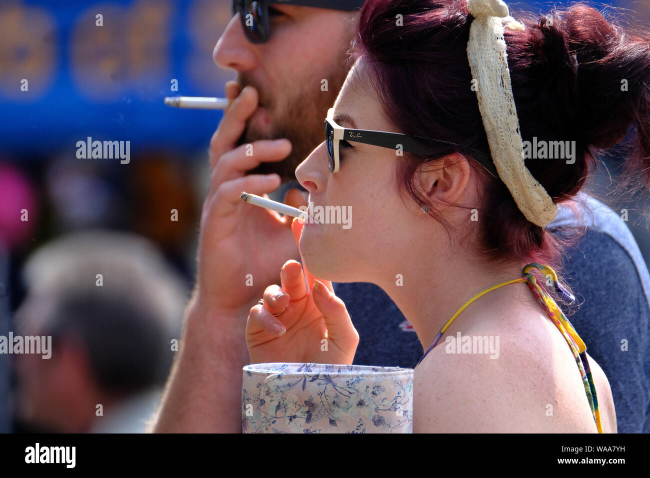 Coppia giovane fumare le sigarette in bright sun. Foto Stock