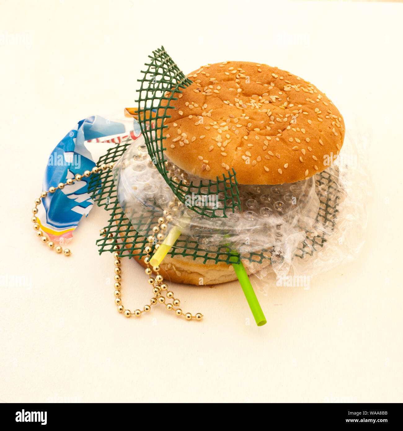 Hamburger pane con riempimento in plastica di sesamo, ricerca personale sulla plastica ambientale e danni alla salute. Foto Stock