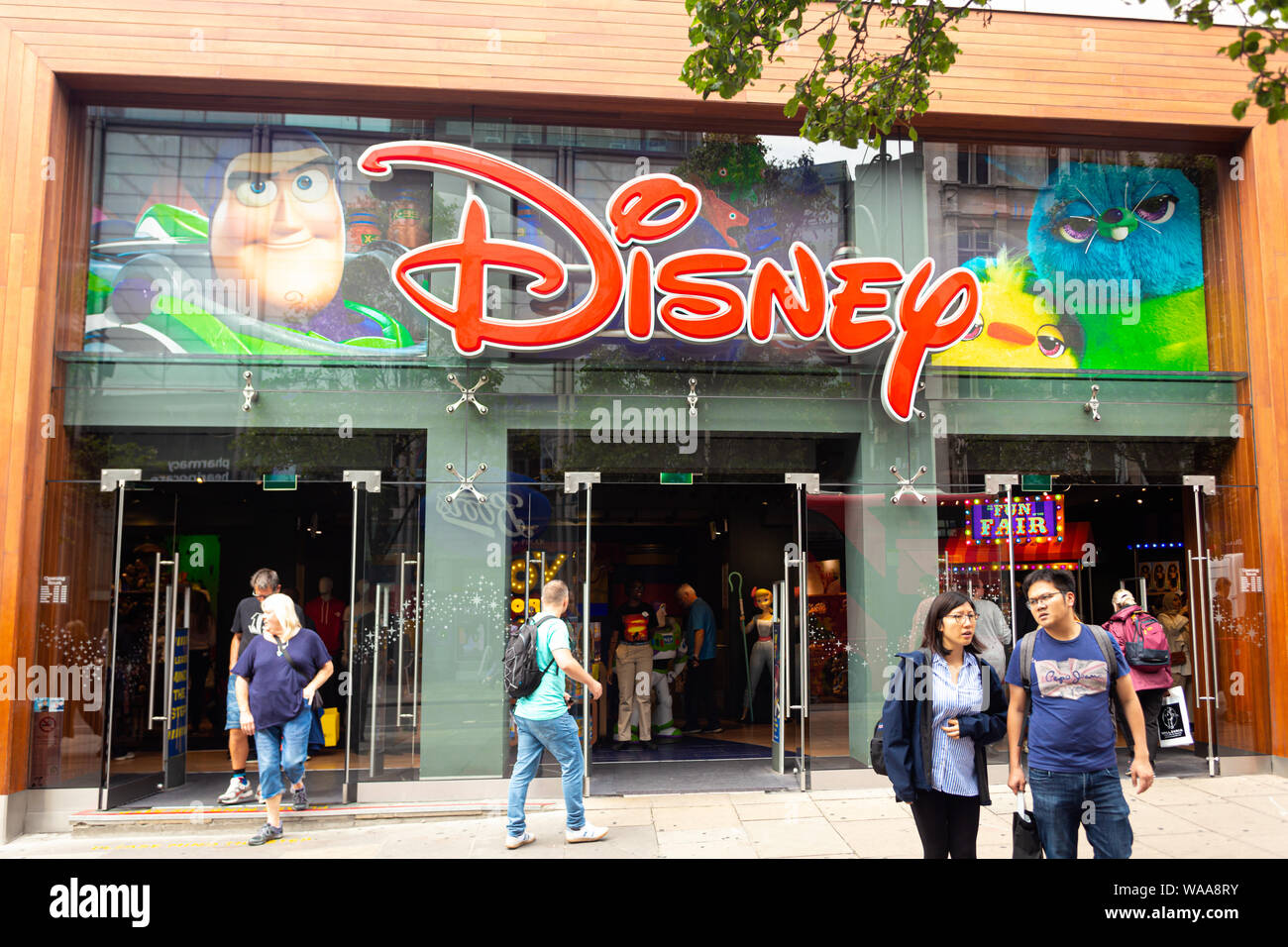 London, Regno Unito - 18 Luglio 2019: la gente a piedi nella parte anteriore del Disney store su Oxford Street, Londra. Oxford Street è una delle più famose strade per lo shopping Foto Stock