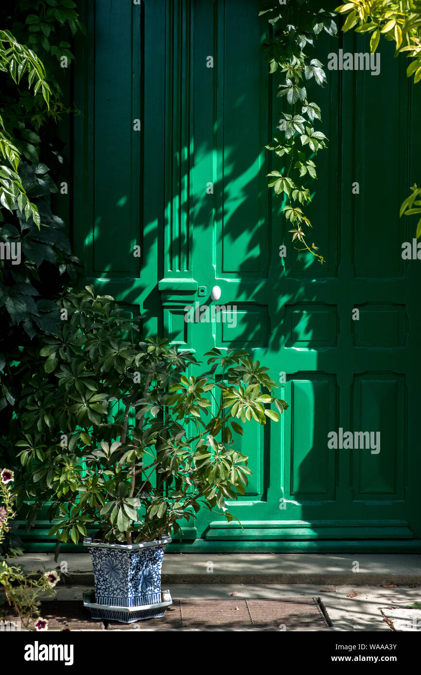 Una luminosa porta verde con piante verdi a Claude Monet a Giverny, Francia Foto Stock
