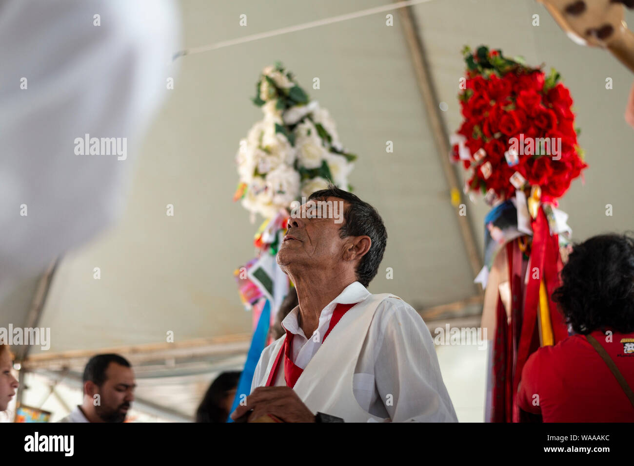 Paranagua, Brasile. 18 Agosto, 2019. Un credente partecipa alla celebrazione dello Spirito Santo durante il Fandango festa in Paranagua. Oltre ai fandango, la celebrazione del Santo Spirito è parte della Caiçara la cultura degli abitanti del Brasile del sud della costa, che mescolano Latin American canti religiosi con i canti popolari della cultura locale per celebrare lo Spirito Santo. Credito: Henry Milleo/dpa/Alamy Live News Foto Stock