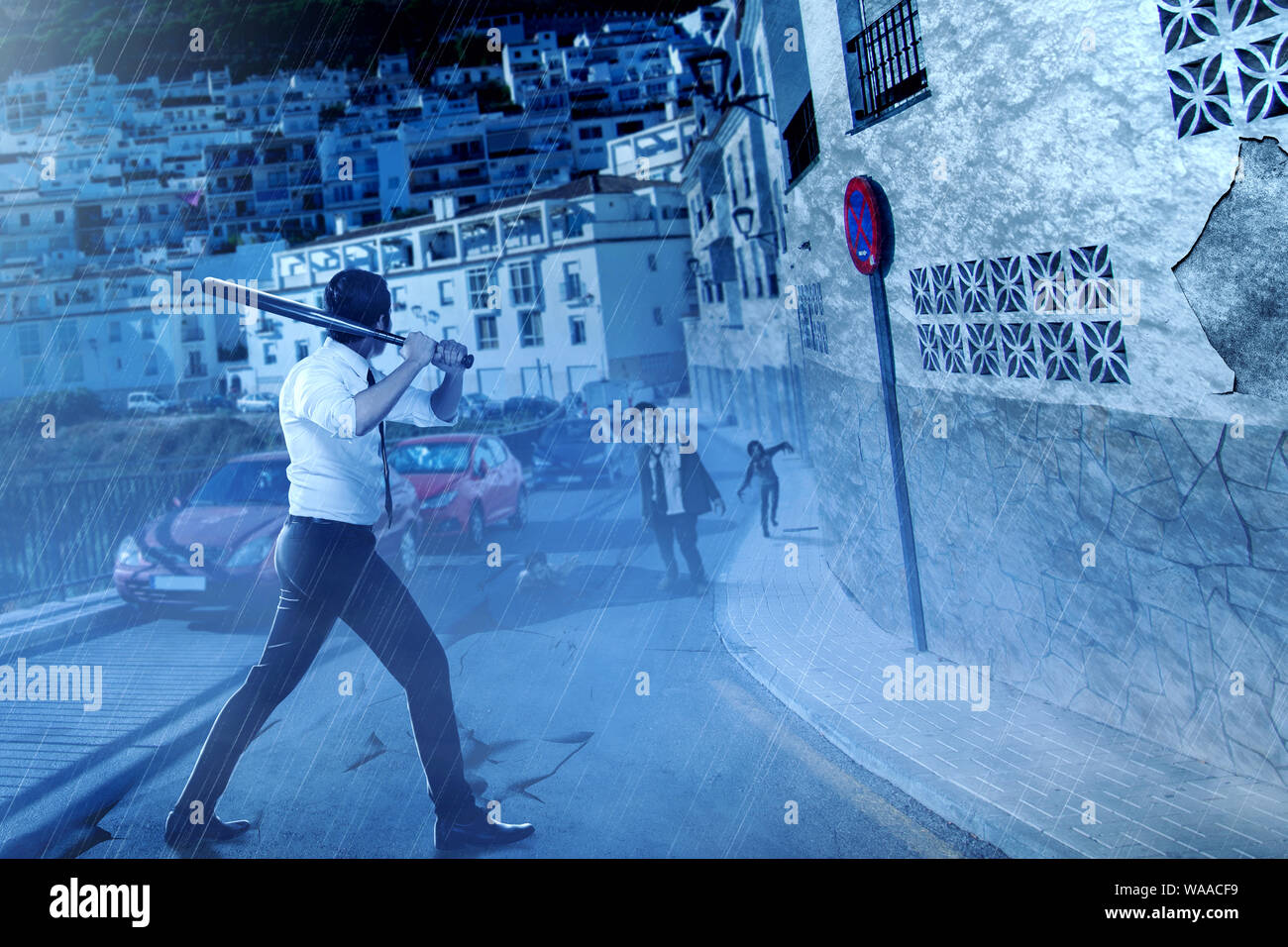 Imprenditore asiatico con una mazza da baseball sul suo volto a mano gli zombie sulla città abbandonate di notte. Concetto di Halloween Foto Stock