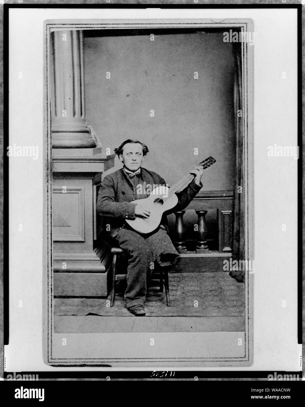 La guerra civile soldato, con una gamba, ritratto a figura intera, seduto, rivolto verso la parte anteriore, tenendo la chitarra Foto Stock La guerra civile soldato, con una gamba, ritratto a figura intera, seduto, rivolto verso la parte anteriore, tenendo la chitarra Foto Stock
