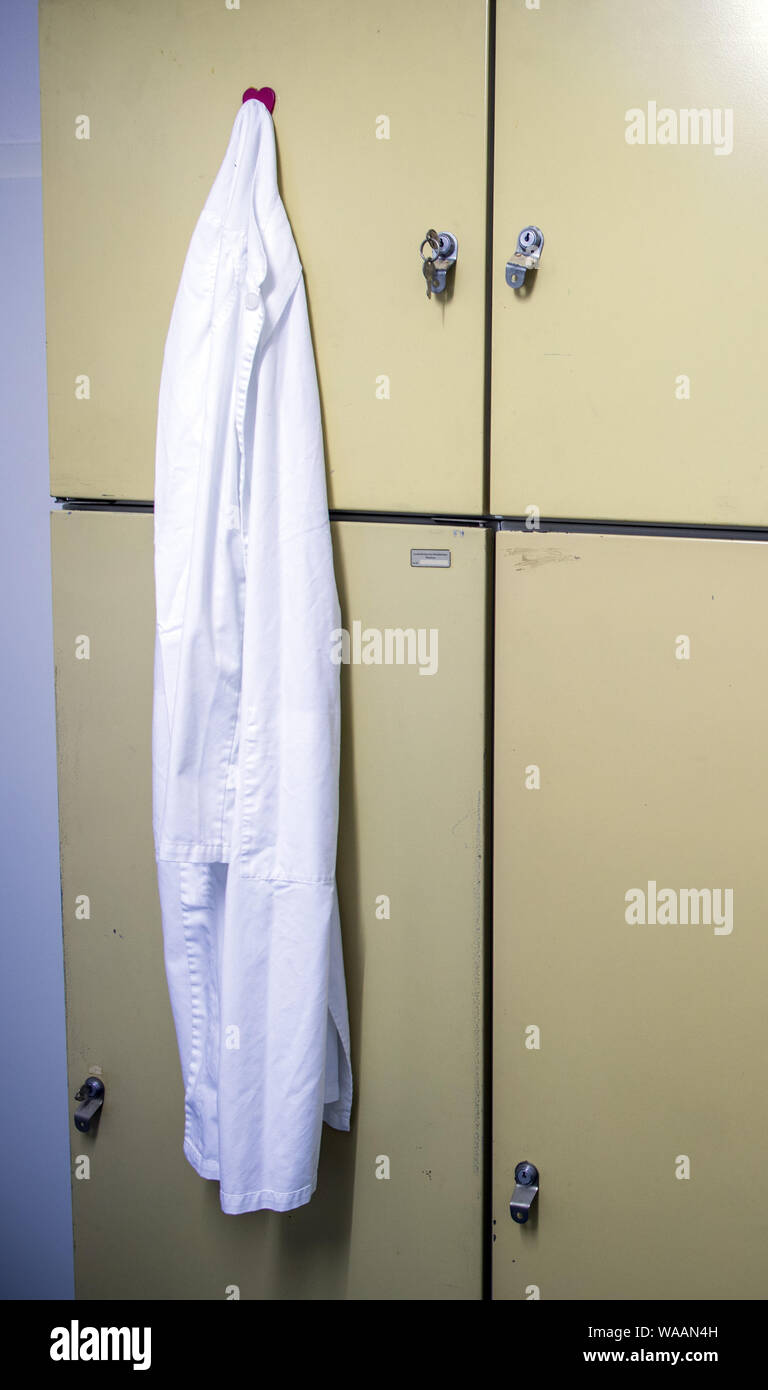 Hohen Wangelin, Germania. Il 25 giugno, 2019. Un medico bianco del mantello e pende da una credenza nella sala pausa del medico di paese in pratica di 74-anno-vecchio Lothar Kruse. Il medico di medicina generale è stato il trattamento di pazienti provenienti dalla regione nella sua pratica in Hohen Wangelin per 40 anni. Alla fine del 2019, Kruse vuole dare la sua pratica, ma finora ha cercato senza successo un successore. Credito: Jens Büttner/dpa-Zentralbild/ZB/dpa/Alamy Live News Foto Stock