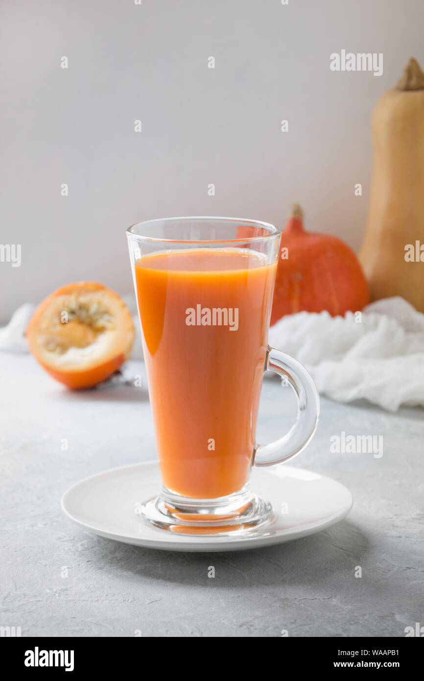 Drink di zucca in vetro su grigio chiaro. Autunno autunno o inverno bevanda calda. Accogliente bevanda salutare. Foto Stock
