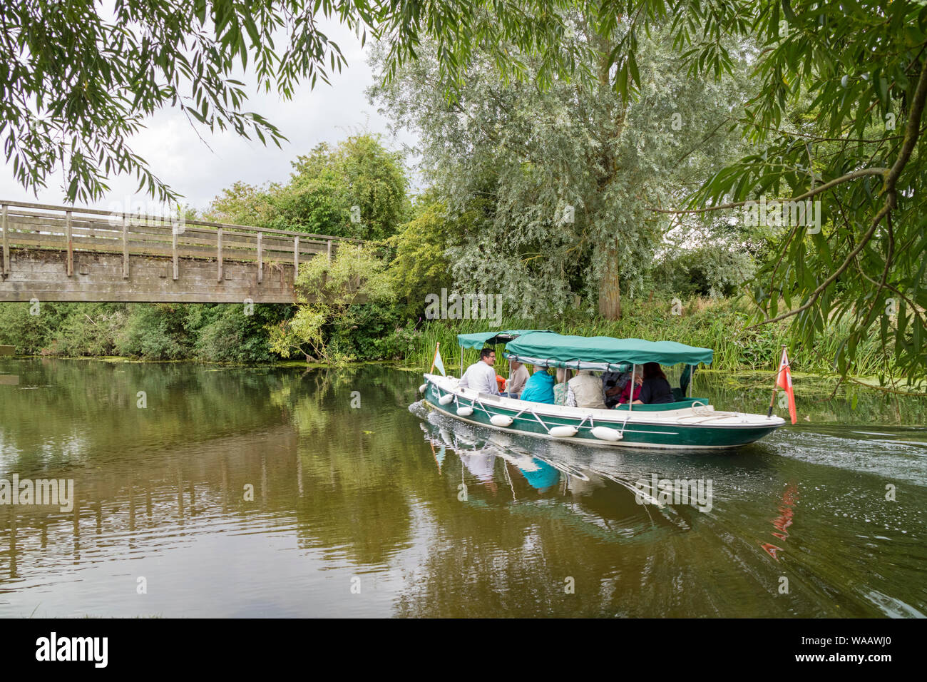 I visitatori di Flatford Mill vai su un viaggio di esplorare in barca sul fiume Stour, Dedham Vale, Suffolk, Inghilterra, Regno Unito Foto Stock