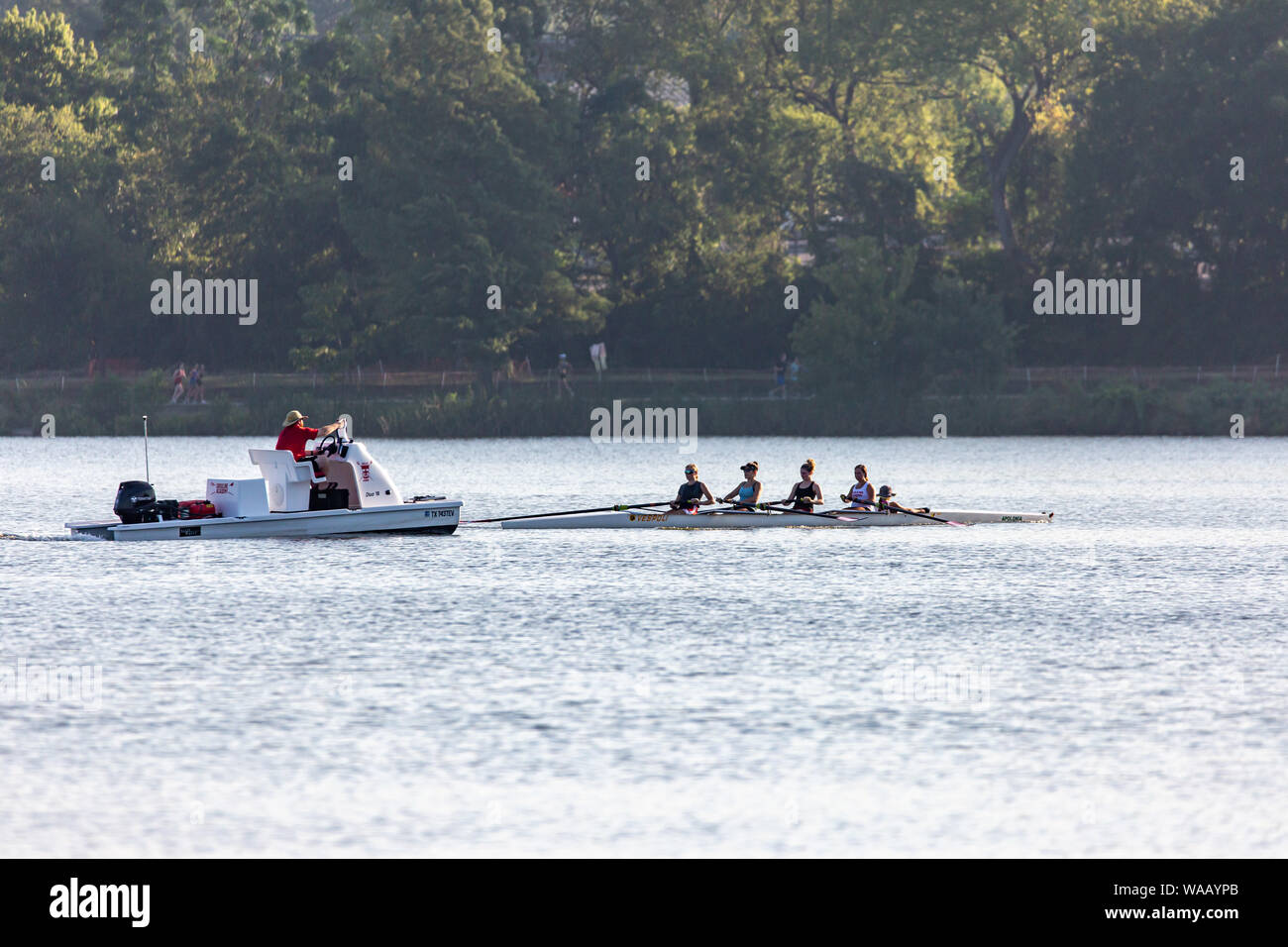 Canottaggio sul lago White Rock a Dallas con imbarcazione di appoggio. Foto Stock