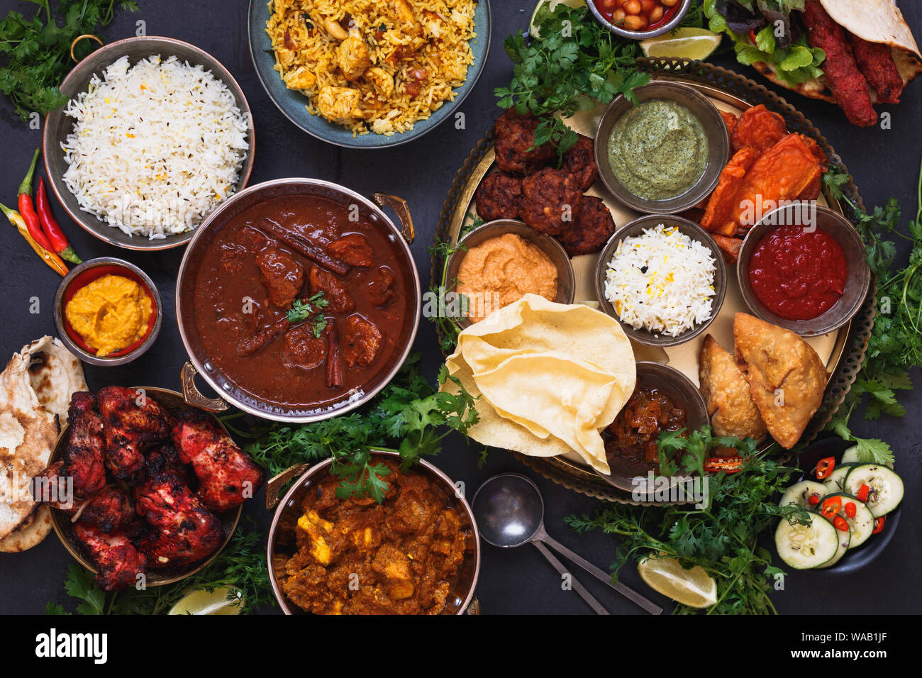 Vari piatti indiani dotate di rogan josh, pollo tikka masala, biryani, pollo tandoori, Spiedini misti e piatto indiano con samosa, pakoras, su Foto Stock