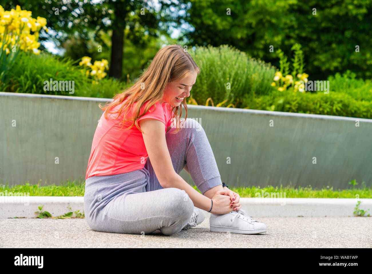 La donna ha avuto un incidente di sport con la sua caviglia e la tiene stretta Foto Stock