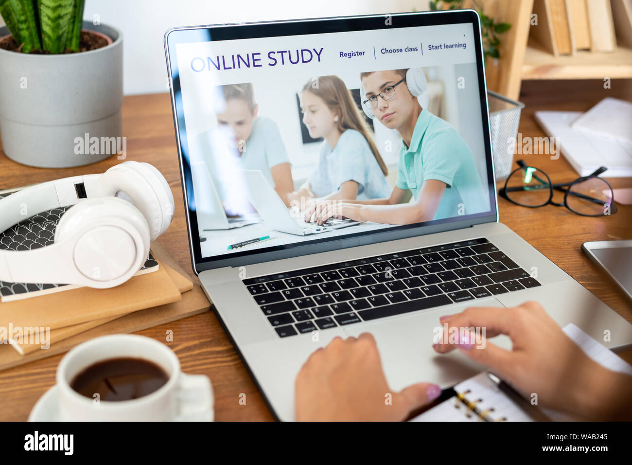 Computer portatile con la homepage di un sito web educativo sul display usato da studenti Foto Stock