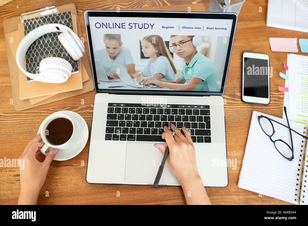 Mano umana sulla tastiera portatile navigare sul sito web di apprendimento a distanza Foto Stock