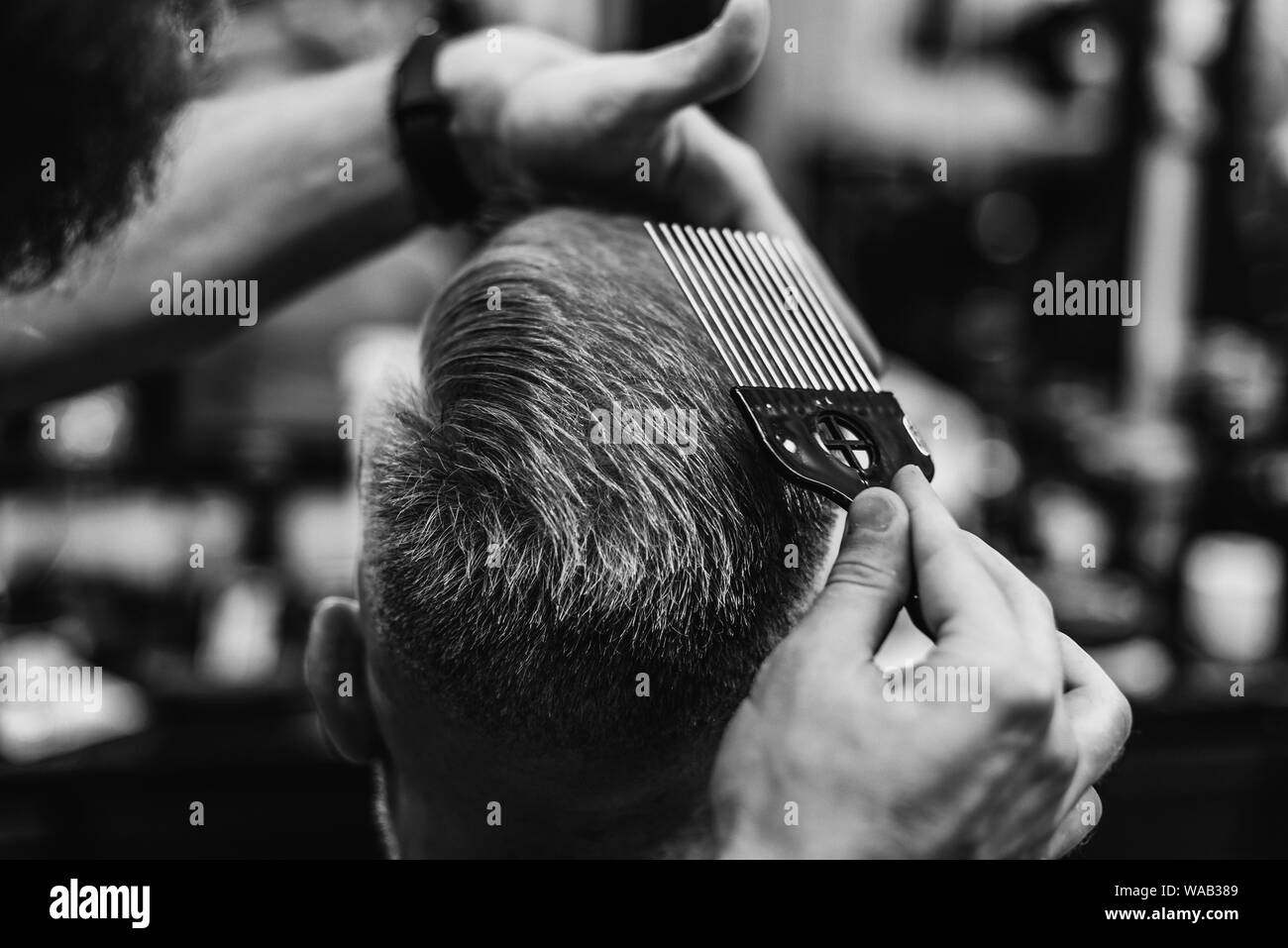 Taglio di capelli uomo in Barberia.taglio di capelli in un parrucchiere. Foto in bianco e nero Foto Stock