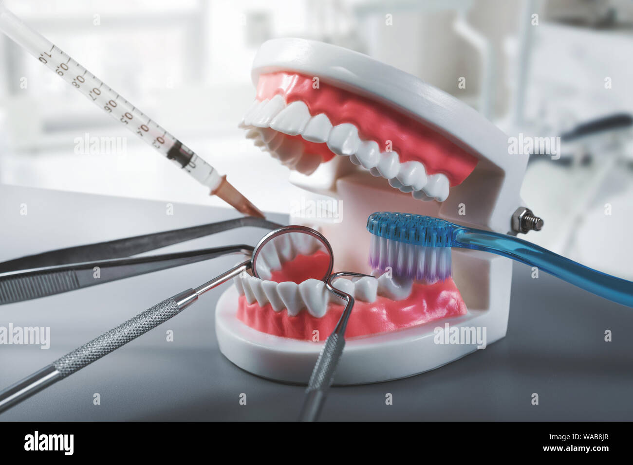Salute dentale e il trattamento - strumenti di dentista con denti modello in cliniche office Foto Stock