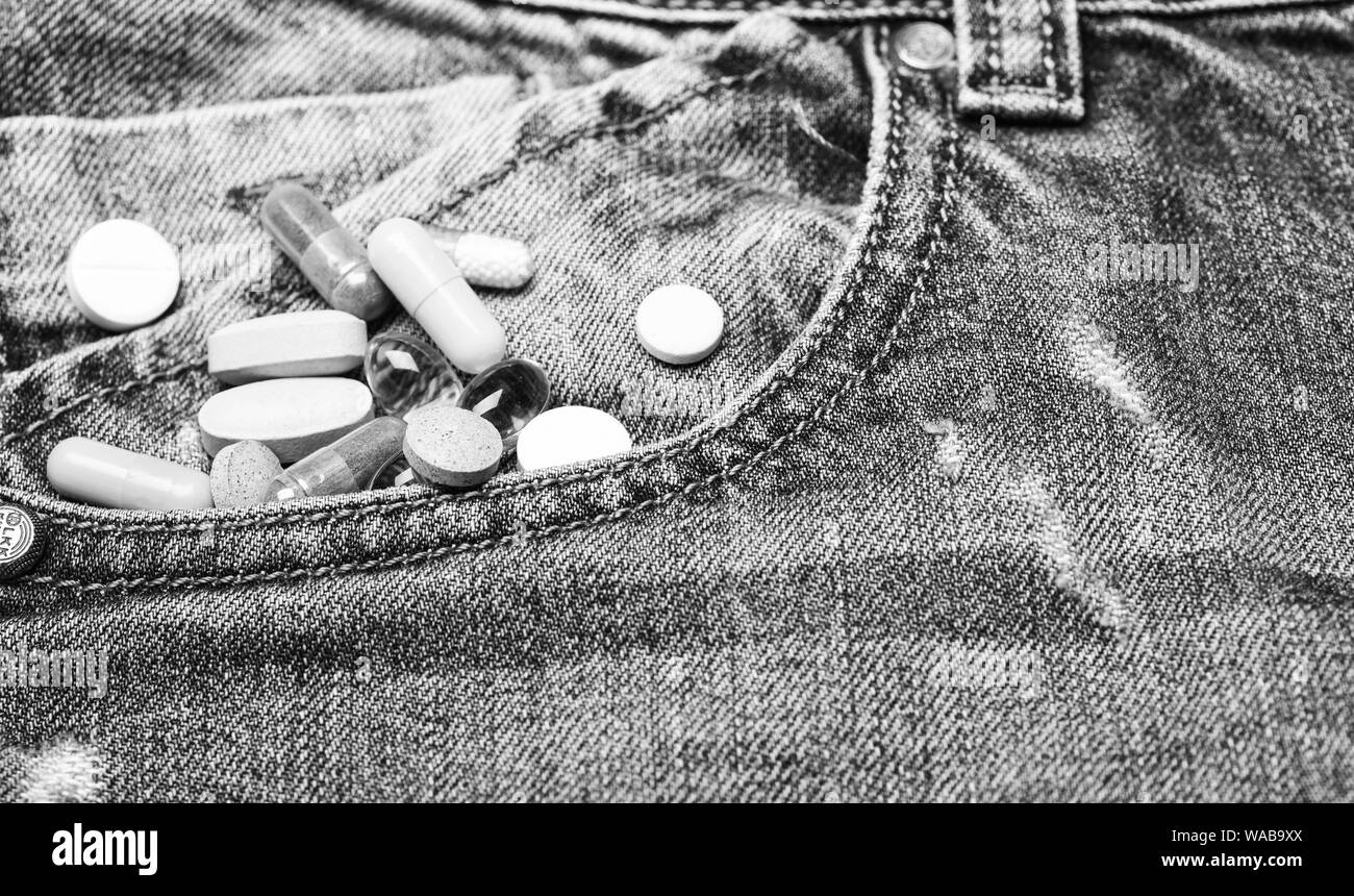 Medicina e concetto di trattamento. Farmaci su sfondo denim. La miscelazione di farmaci. Trattamento rapido. Medicinali soggetti a prescrizione medica. La cura della salute e della malattia. La dose e la tossicodipendenza. La tossicodipendenza. Set di pillole colorate. Foto Stock