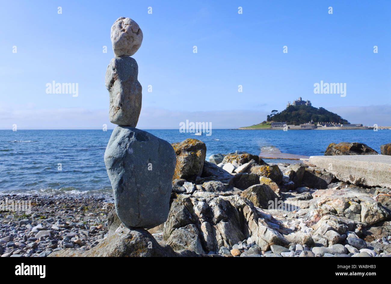 Pietre di bilanciamento sulla spiaggia di Marazion, Cornwall con St. Michael's Mount in background - Giovanni Gollop Foto Stock