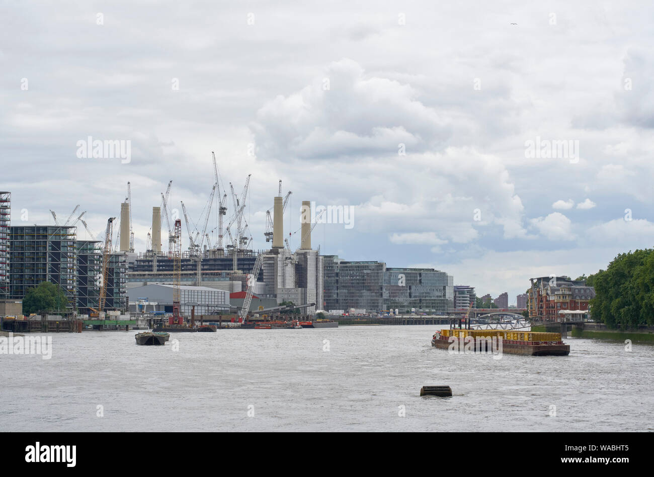 Vista da est con il fiume su giorno nuvoloso. Battersea Power Station 2019, Londra, Regno Unito. Architetto: vari, 2019. Foto Stock