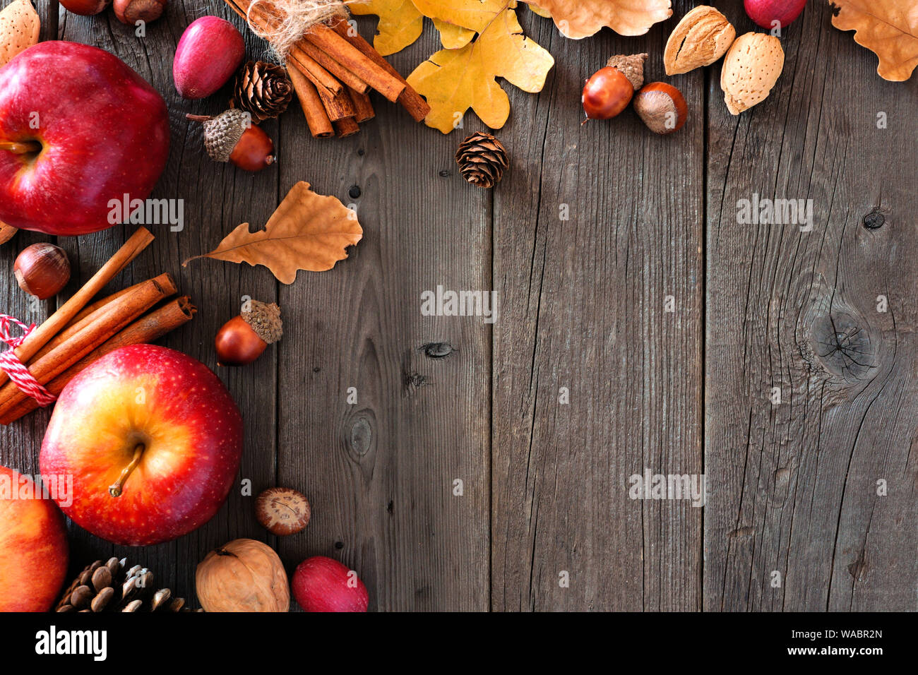 Angolo di autunno confine di mele e cadere gli ingredienti su di un legno rustico sfondo con spazio di copia Foto Stock