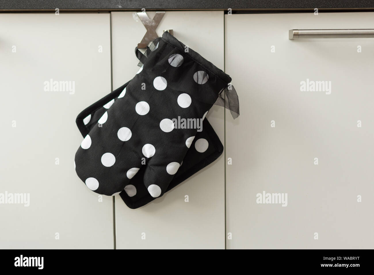 Potholder e un forno a muffola in cucina moderna con interni. Cucina elegante mitt. Foto Stock